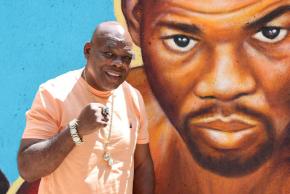 Boxer Iran Barkley poses next to painting of himself at Patterson Houses mural.