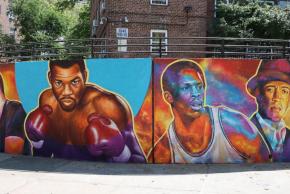 Mural featuring colorful illustrations of boxer Iran Barkley, basketball player Nate Archibald, actor Luis Antonio Ramos, and artist Prince Royce.
