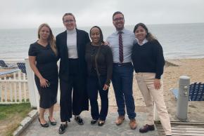 Members of the Moving Justice Forward team pose for a photo by the beach.