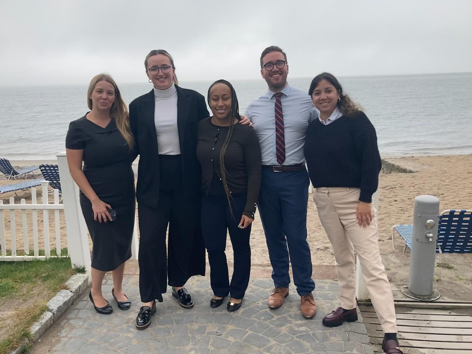 Members of the Moving Justice Forward team pose for a photo by the beach.