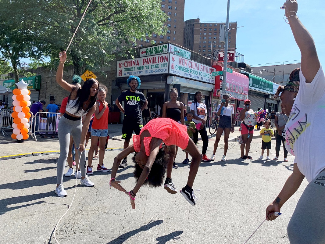 Community event, kids double dutch. A girl flips while jumping