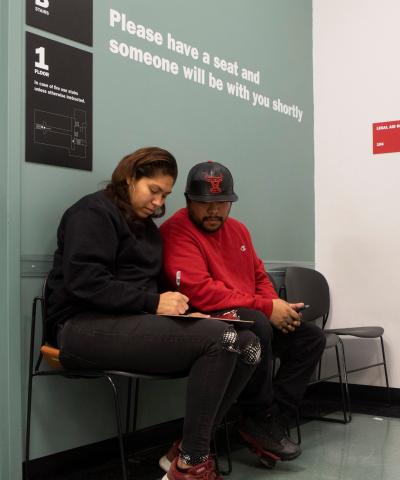 Two people sit together in a waiting area at the Red Hook Community Justice Center.