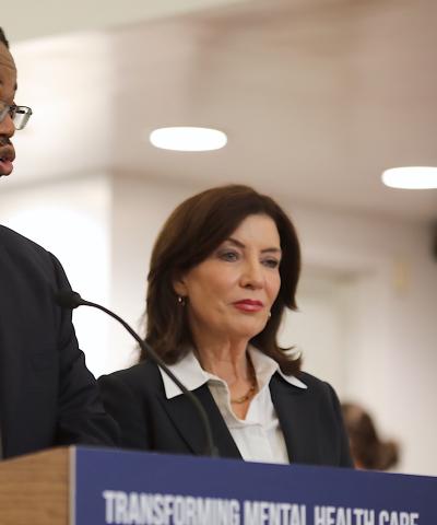 Jethro Antoine, the Center's Chief Program Officer of Court Reform, speaks next to Governor Kathy Hochul at the Midtown Community Justice Center.