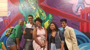 Youth Justice Board and Jannelle Ramdeen in front of a mural