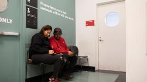 Two people sit together in a waiting area at the Red Hook Community Justice Center.