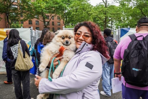 Woman holding a dog and smiling at Castle Hill dog park opening.