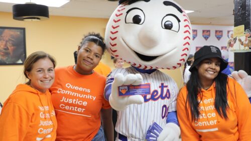 Two Queens Community Justice Center pose with the Mets mascot