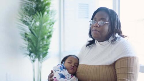 Reunited mother and child from Strong Starts program speak in front of window