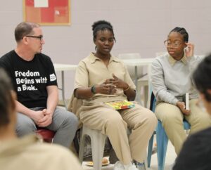 Incarcerated women and staff from Freedom Reads sit at a book discussion at the Edna Mahan Correctional Facility.