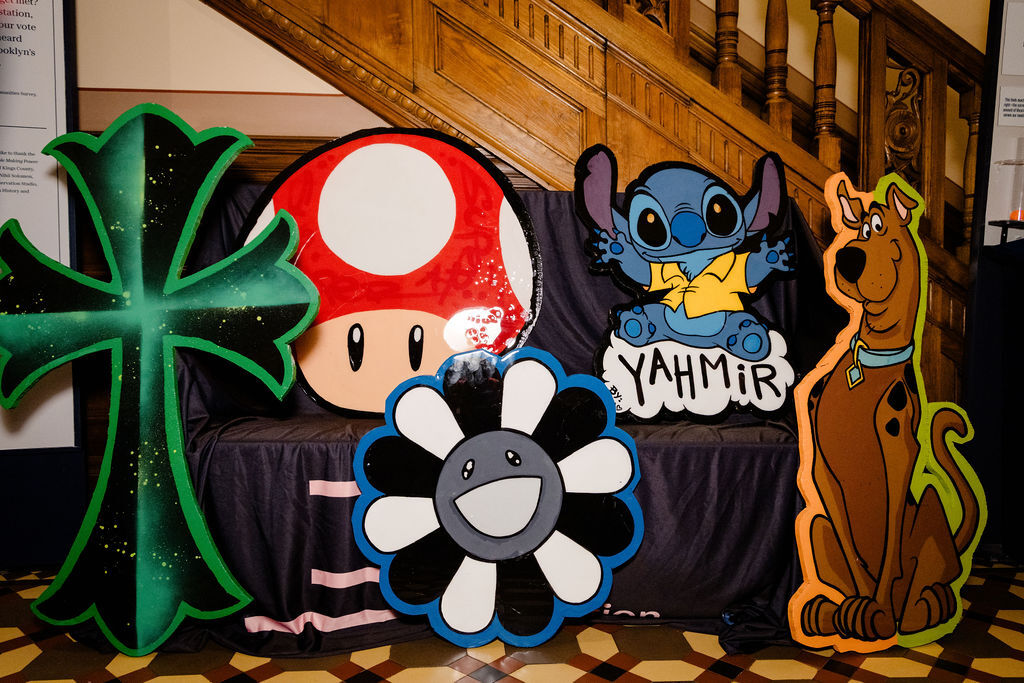 Cartoon-style woodcut designs featuring well-known characters like Scooby Doo, Stitch from "Lilo and Stitch," and a mushroom in the style of "Mario Kart."